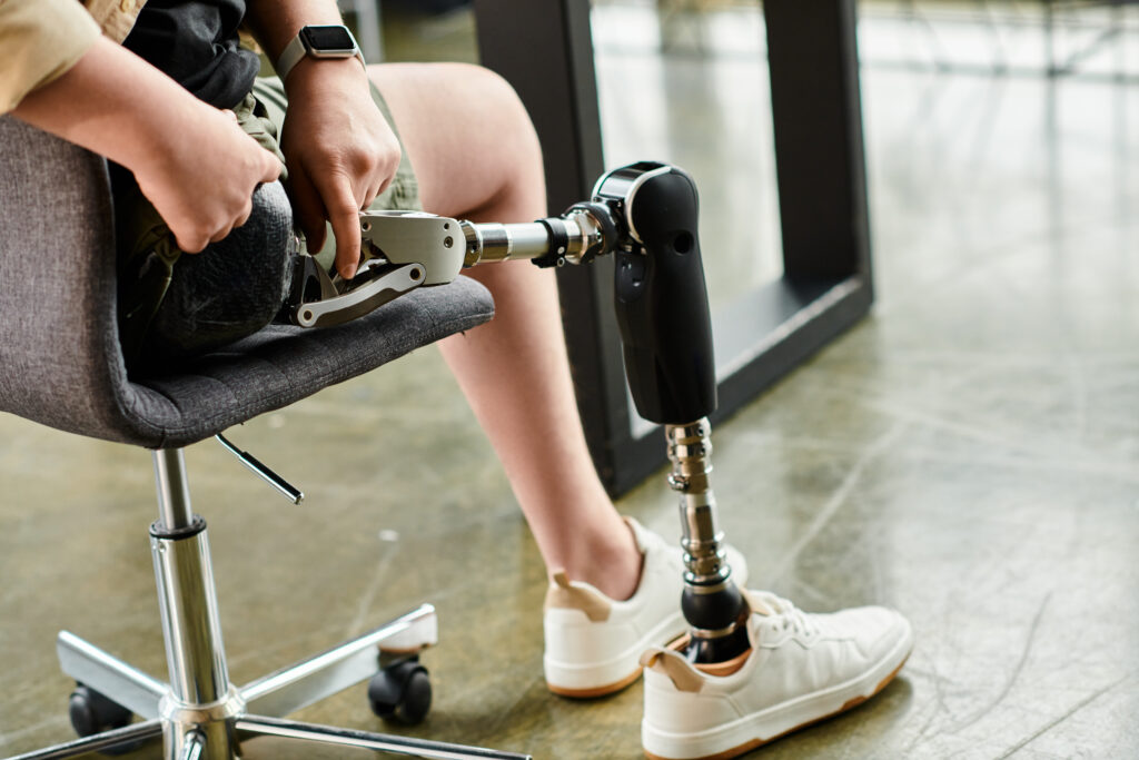 Good looking businessman with prosthetic leg sitting on chair in office.